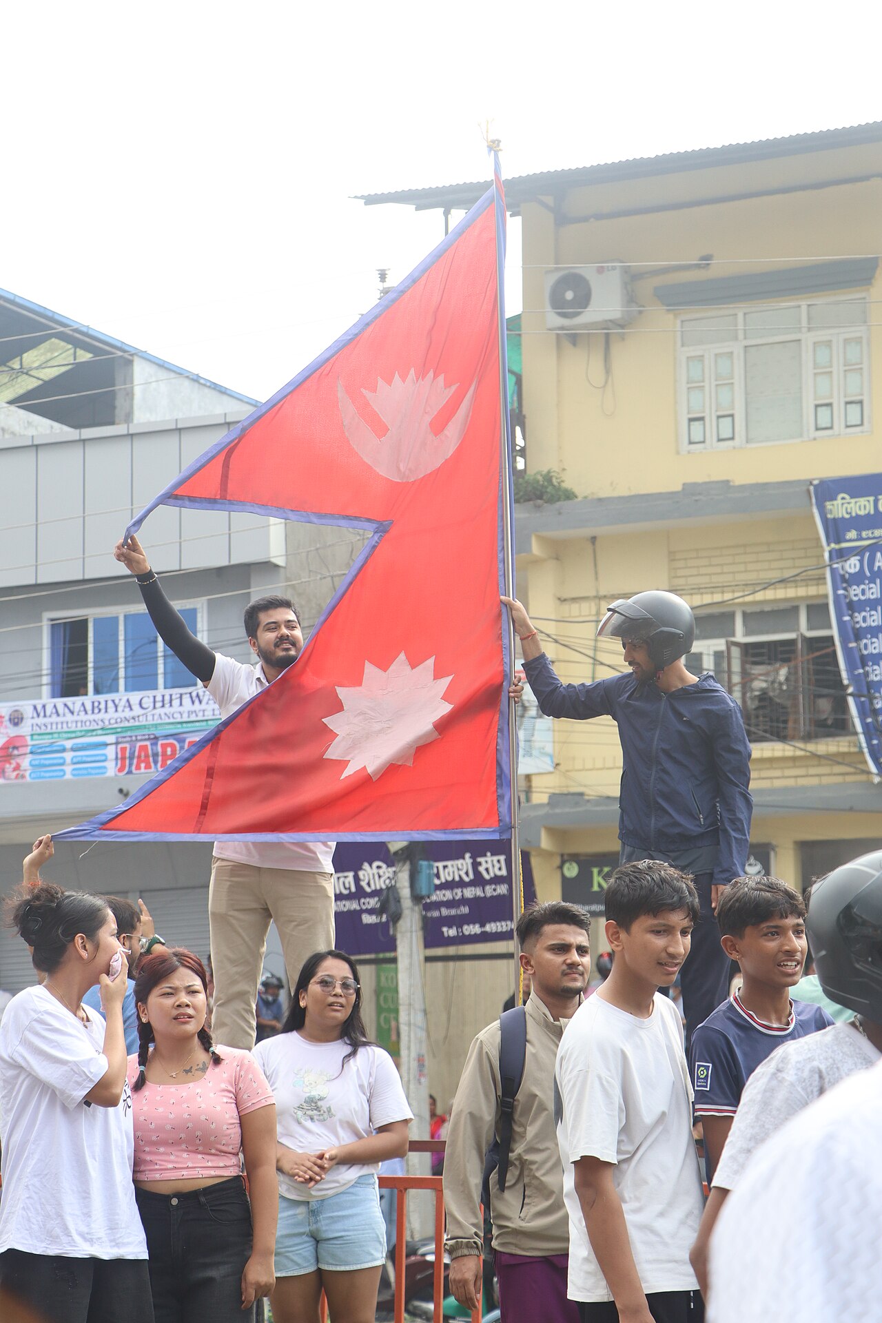 A young protester holds the national flag of Nepal aloft above a crowd in Chitwan, Nepal, on September 9, 2025